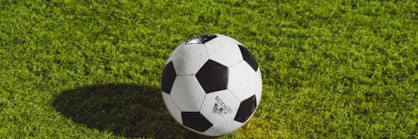 足球战术分析图 - 教练在战术板前讲解，球员围坐聆听